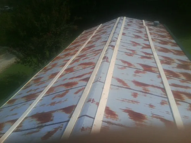 Rusted metal roof panels with new wood purlins before replacement — Storm Damage Roof Repair in Big Rock by Roofing Brothers